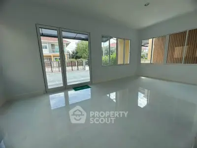 Spacious empty living room with large windows and glossy tiled floor