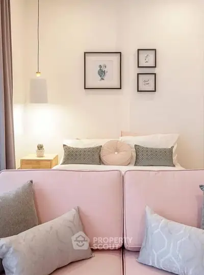 Cozy living room with pastel pink sofa and elegant wall art