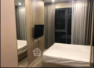 Modern bedroom with sleek design and large window for natural light.