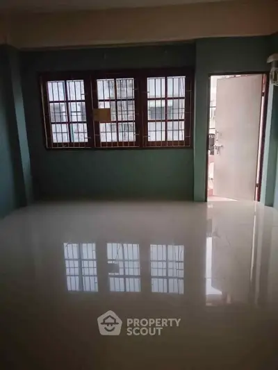 Spacious empty room with large windows and glossy tiled floor