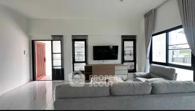 Spacious modern living room with large windows and cozy seating area