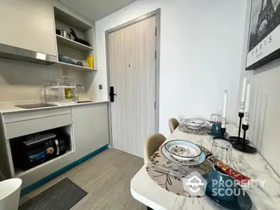 Modern kitchen with dining area, featuring sleek cabinetry and stylish decor.