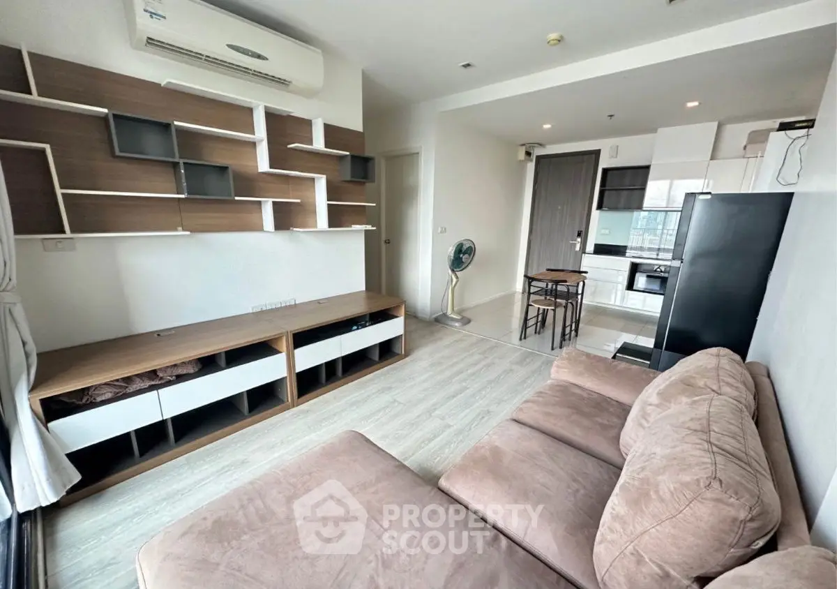Modern living room with stylish shelving and cozy sofa in open layout apartment.