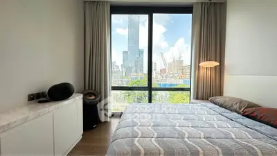 Modern bedroom with city view, featuring large window and stylish decor.