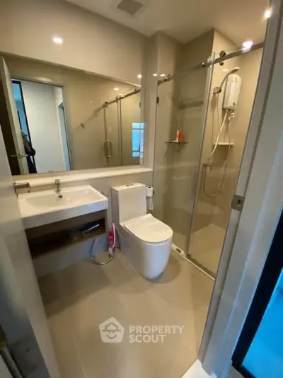 Modern bathroom with glass shower and sleek fixtures in a contemporary apartment.
