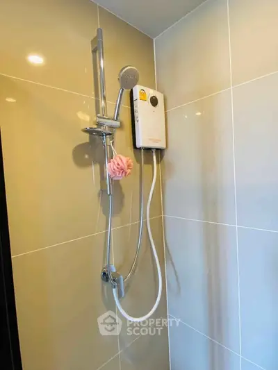 Modern bathroom shower with sleek design and water heater in contemporary home.