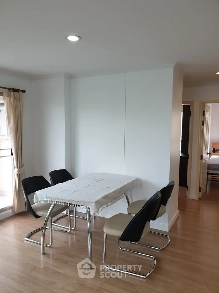 Modern dining area with sleek chairs and natural light in a stylish apartment.