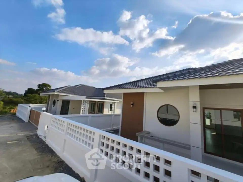 Modern single-story house with stylish design and spacious outdoor area under a clear blue sky.
