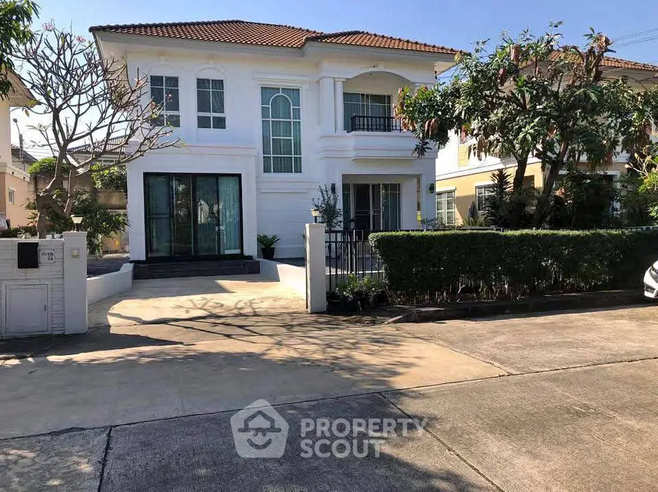 Charming two-story house with lush garden and spacious driveway in a serene neighborhood.