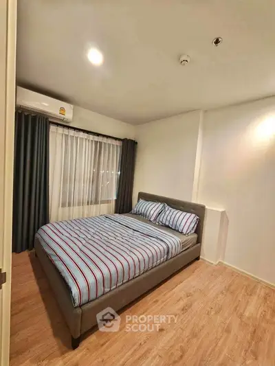 Cozy bedroom with modern decor and wooden flooring in a stylish apartment.