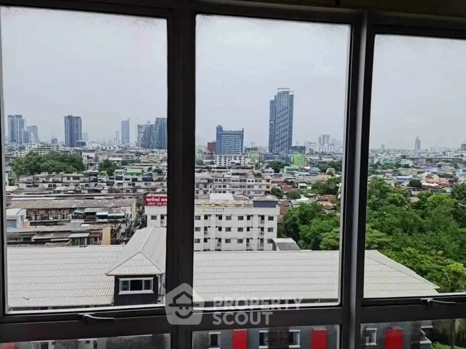 Stunning cityscape view from high-rise window showcasing urban skyline and greenery.