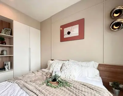 Modern bedroom with stylish decor and cozy bedding in a contemporary apartment.