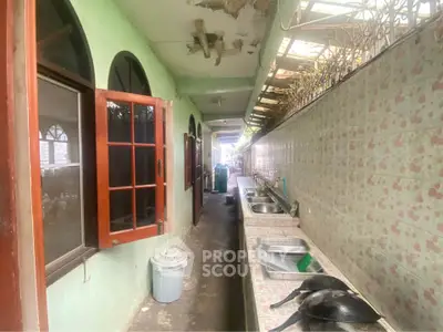 Spacious outdoor kitchen with multiple sinks and open windows, ideal for large gatherings.