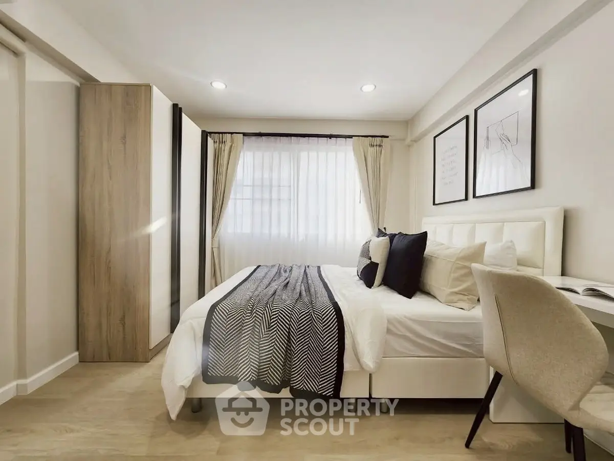 Modern bedroom with stylish decor and natural light, featuring a cozy bed and elegant furnishings.