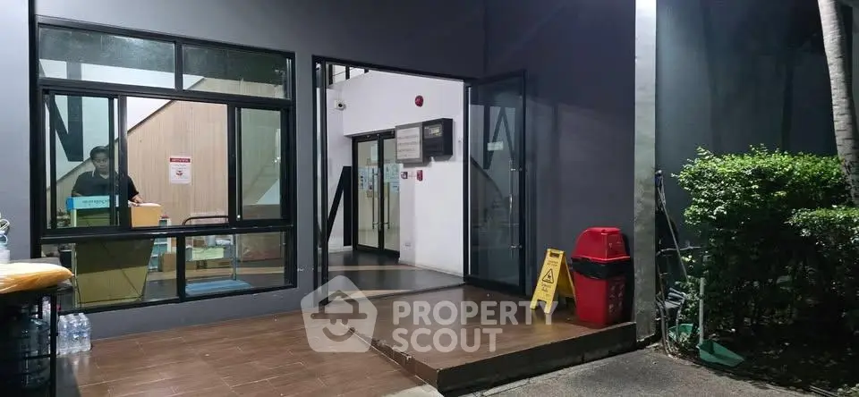 Modern building entrance with glass doors and night lighting