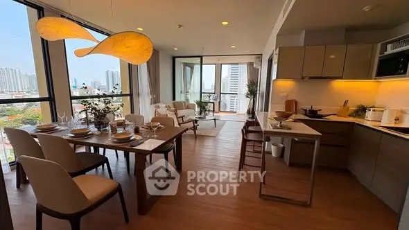 Modern open-plan living room and kitchen with city view, stylish decor, and elegant lighting.
