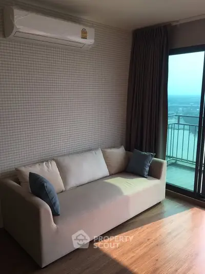 Cozy living room with modern sofa and balcony view in a stylish apartment.