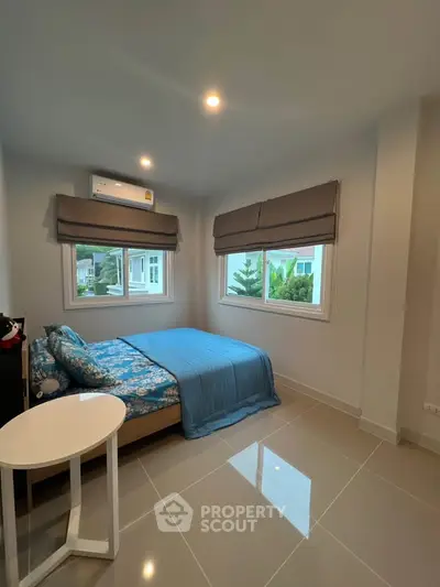 Modern bedroom with large windows and stylish decor in a contemporary home.