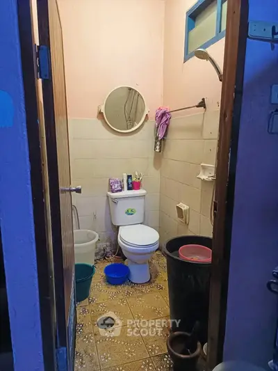 Compact bathroom with basic amenities and tiled flooring.
