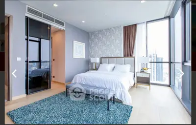 Luxurious modern bedroom with floor-to-ceiling windows and city view, featuring elegant decor and a plush area rug.