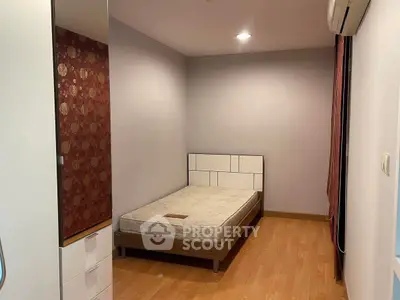 Cozy bedroom with modern design and wooden flooring in a stylish apartment.