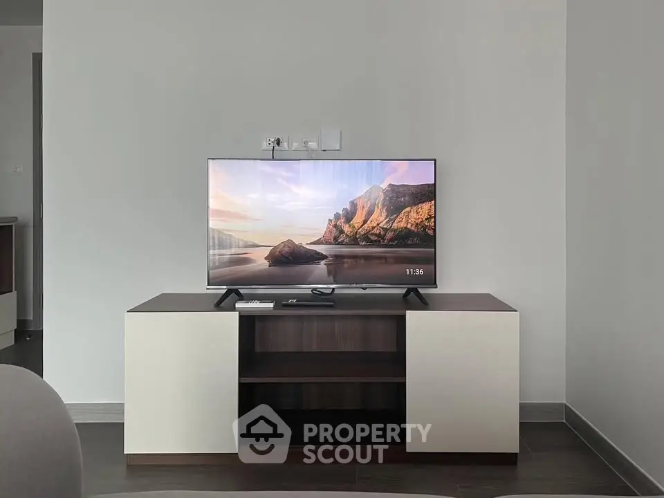 Modern living room with sleek TV stand and flat-screen TV, minimalist design.