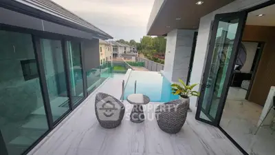 Luxurious modern balcony with pool view and stylish outdoor seating in upscale property.