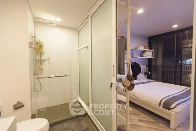 Modern studio apartment with glass shower and cozy bedroom