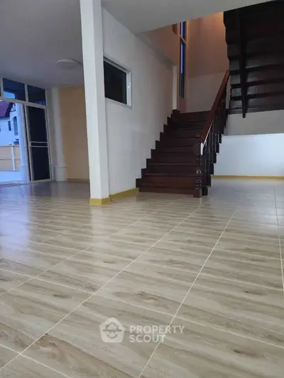 Spacious interior with elegant wooden staircase and tiled flooring