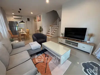 Modern living room with stylish furniture and open dining area, featuring a cozy ambiance and contemporary design.