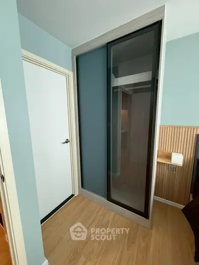 Modern bedroom with sleek sliding closet doors and stylish wood paneling