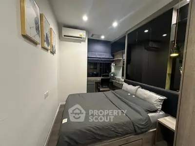 Modern bedroom with stylish decor and workspace, featuring cozy bedding and ambient lighting.