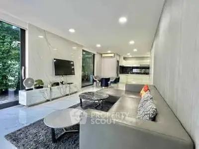 Spacious modern living room with sleek furniture and open kitchen layout