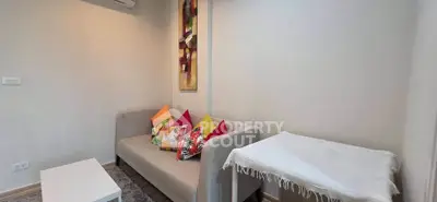 Cozy living room with modern sofa and colorful cushions, perfect for relaxation.