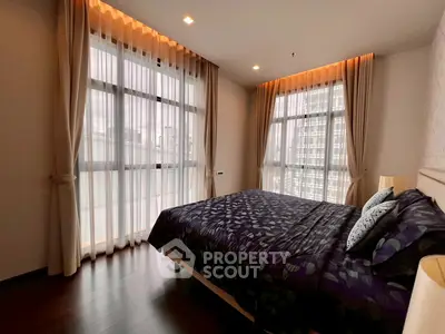 Spacious bedroom with large windows and elegant curtains in modern apartment