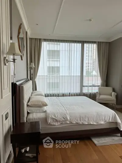 Luxurious bedroom with elegant decor and large windows offering city views