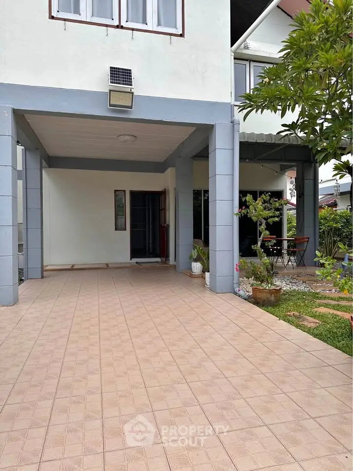 Spacious covered carport with tiled flooring and garden view in modern residential property.