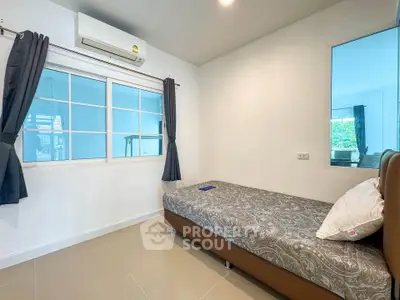 Cozy bedroom with modern decor and large window for natural light.