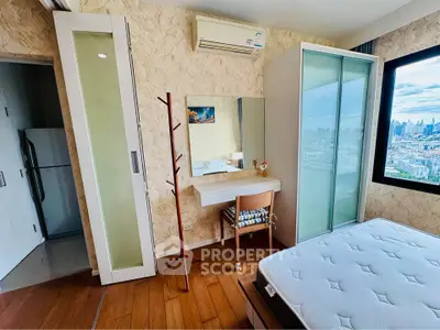 Modern bedroom with city view, featuring stylish furniture and ample natural light.