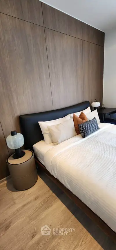 Modern bedroom with stylish decor and wooden accent wall