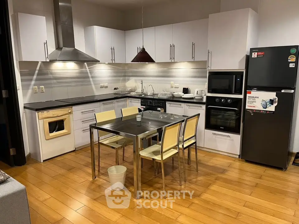 Modern kitchen with sleek appliances and dining area in stylish apartment