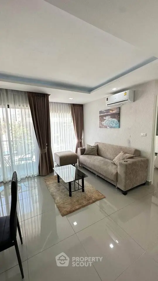 Modern living room with sleek furniture and large windows offering natural light.
