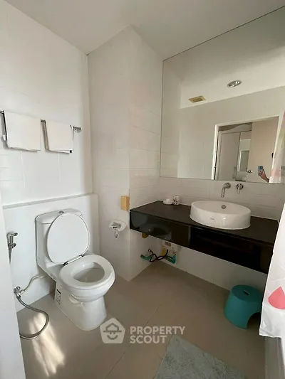 Modern bathroom with sleek fixtures and large mirror in a contemporary home.