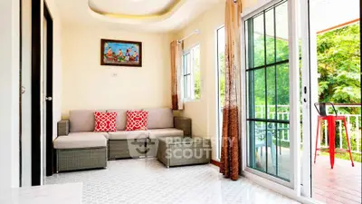 Bright living room with modern decor and sliding glass doors leading to a lush balcony view.