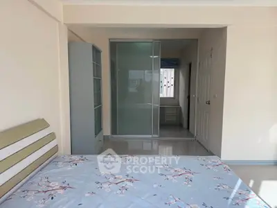 Spacious bedroom with modern sliding glass closet and natural light