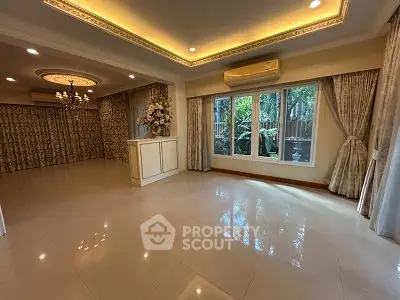 Elegant living room with chandelier and large windows overlooking garden
