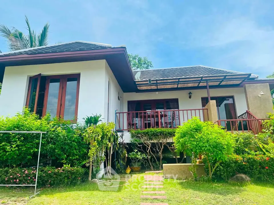 Charming single-story home with lush garden and inviting porch, perfect for serene living.