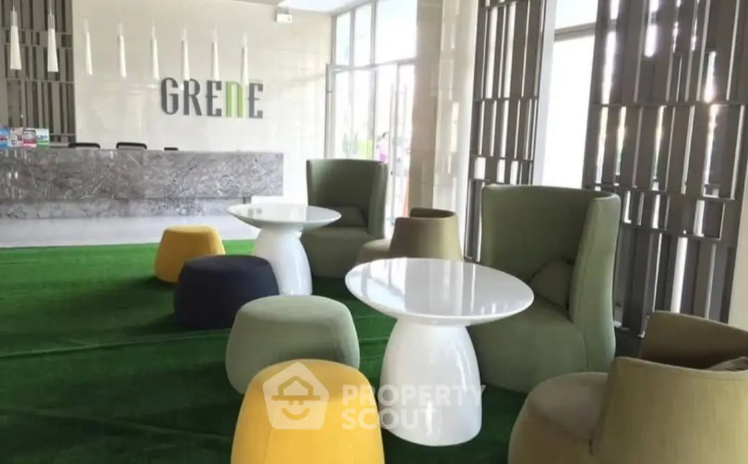Modern lobby with stylish seating and green accents in a contemporary building.