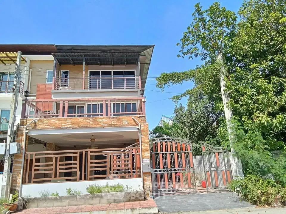 Spacious three-story townhouse with gated entrance and lush greenery, perfect for family living.