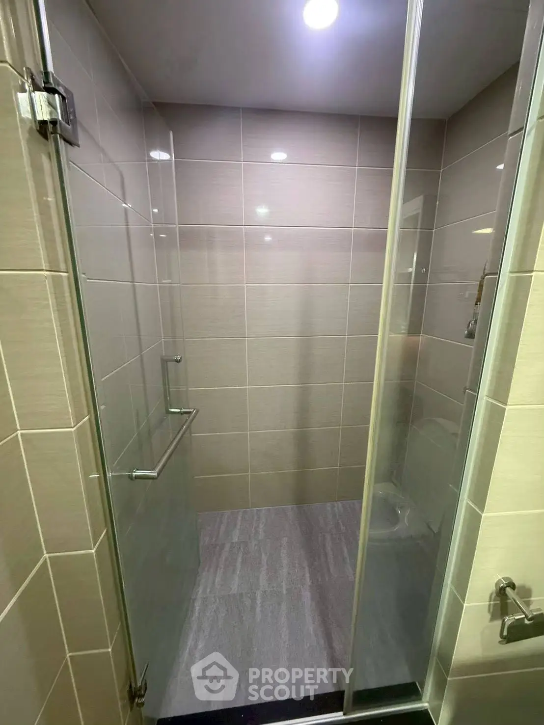 Modern shower area with glass doors and sleek tile design